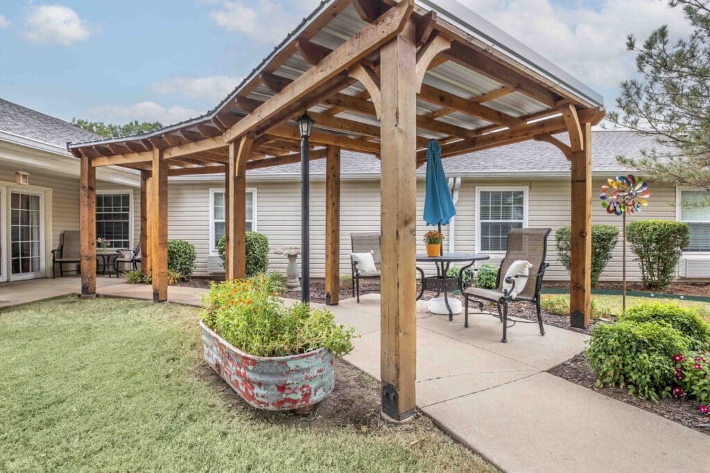 Exterior image of an outdoor seating area with comfortable seating and beautiful plants at Inspirations at Bartlesville.